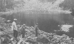 Three Trail Blazers at shore of rockbound lake